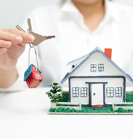 Person holding house key with model home for Abroad Study Consultancy Kerala